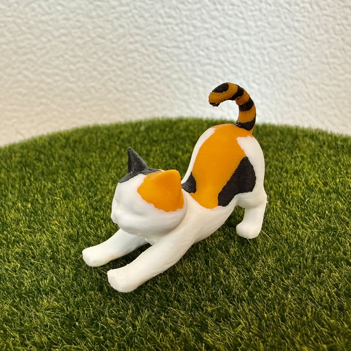 伸びをする三毛猫 1匹を横から見たところ