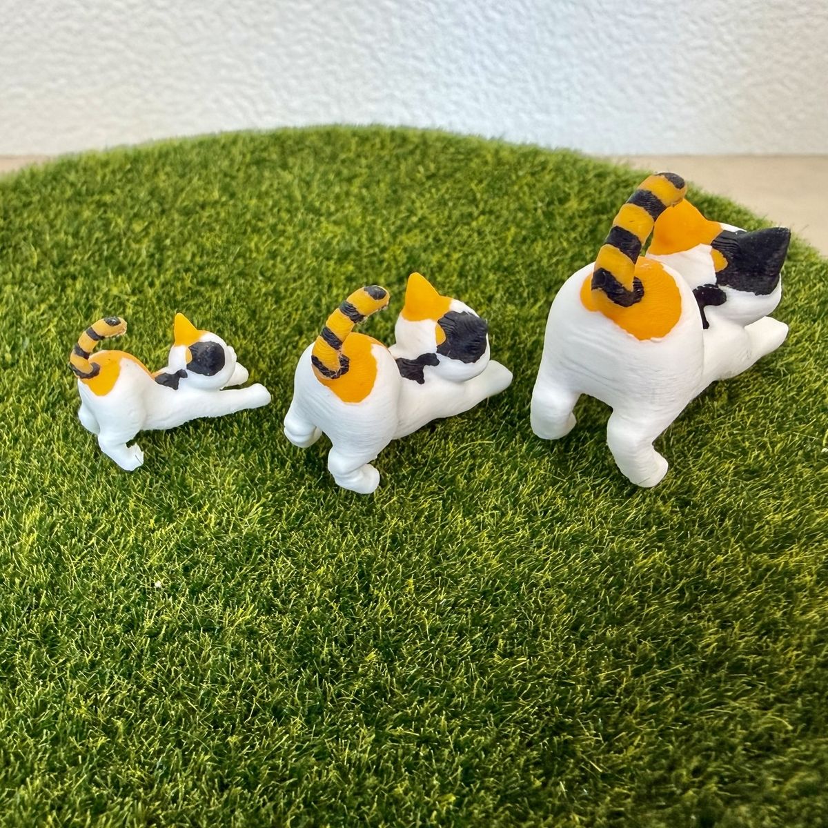 伸びをする三毛猫 大・中・小の3サイズを並べたところ
